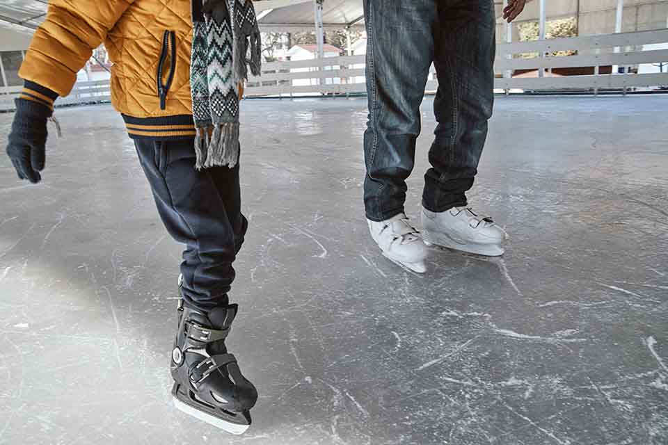 Grandfather and grandson on the ice rink, ice skating